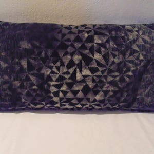 May include: A dark grey and silver geometric patterned throw pillow. The pillow is made of a soft, velvety fabric.