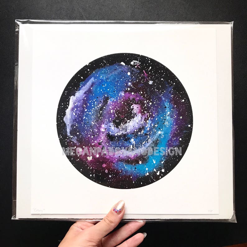May include: A watercolor painting of a galaxy with shades of blue, purple, and white. The galaxy is painted in a circle on a white background.