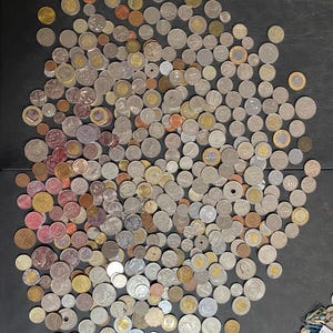 May include: A white ceramic mug with a black handle and the text "But First, Coffee" in a black, handwritten-style font. The mug is likely 11-15 ounces and sits on a white surface.