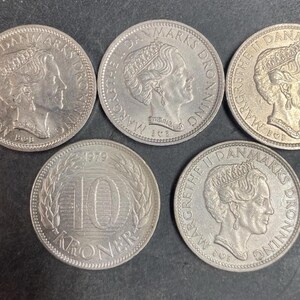 May include: Five silver-colored Danish coins. Four coins feature the profile of Queen Margrethe II with the text MARGRETHE II DANMARKS DRONNING. One coin displays the number 10, the year 1979, and the word KRONER surrounded by a wheat wreath design.