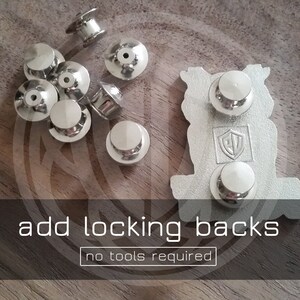 May include: Silver metal pin backs with a locking mechanism.  The pin backs are designed to be easy to use and require no tools to attach.  Add locking backs to your pins for a secure and professional look.  "add locking backs no tools required"