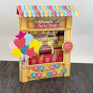 Carte de magasinage de blagues Party Shop - Carte de voeux 3D faite main en forme de magasin de jeux de société ou de magasin de blagues. Carte d'anniversaire pour enfants.