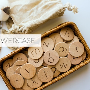 May include: A wicker basket filled with wooden lowercase letter tiles. The tiles are arranged in a random order. The word "lowercase" is printed in white on a brown background.