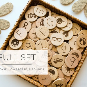 May include: A wicker basket filled with wooden circles featuring uppercase and lowercase letters, numbers, and sound icons. The text "FULL SET UPPERCASE, LOWERCASE, & SOUNDS" is displayed below the basket.