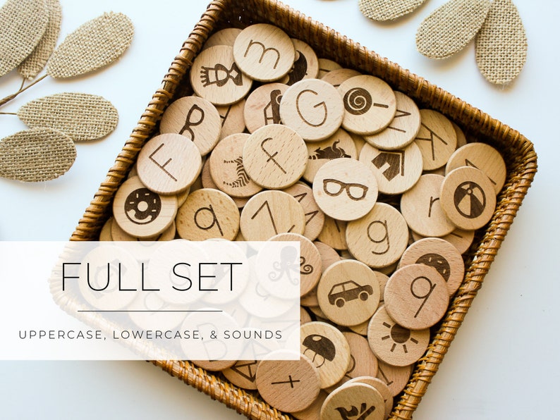 May include: A wicker basket filled with wooden circles featuring uppercase and lowercase letters, numbers, and sound icons. The text "FULL SET UPPERCASE, LOWERCASE, & SOUNDS" is displayed below the basket.