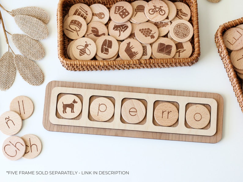 May include: Wooden tray with five slots for letter tiles. The tray has the word "perro" spelled out with tiles. There are additional letter tiles and a basket of wooden tiles with various images on them.