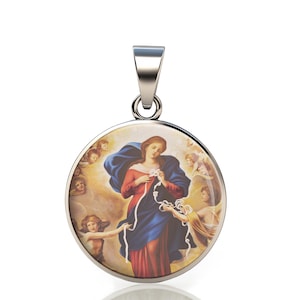 Può includere: Ciondolo rotondo argentato con un'immagine religiosa di una donna in abito rosso e blu, circondata da angeli. Il ciondolo ha un'ansa argentata per una catena. L'immagine raffigura una donna che fa un nodo.