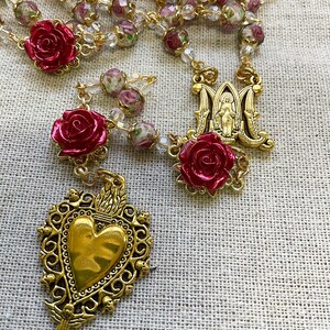 Immaculate Mary centerpiece and Sacred Heart of Jesus medal framed by red rose beads and floral lampwork glass beads on a gold-tone Catholic rosary.