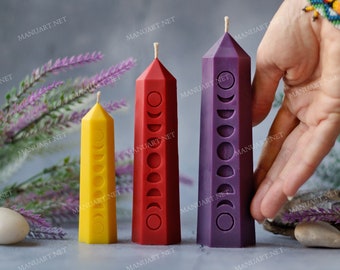 Può includere: Tre candele a pilastro con diversi colori e fasi lunari intagliate. Le candele sono gialle, rosse e viola.