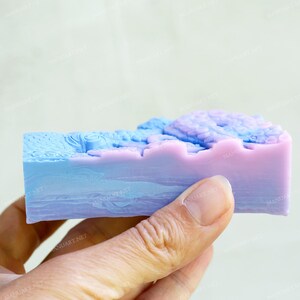 May include: A bar of soap with a blue and purple swirl design. The soap is in the shape of a rectangle and has a textured surface.