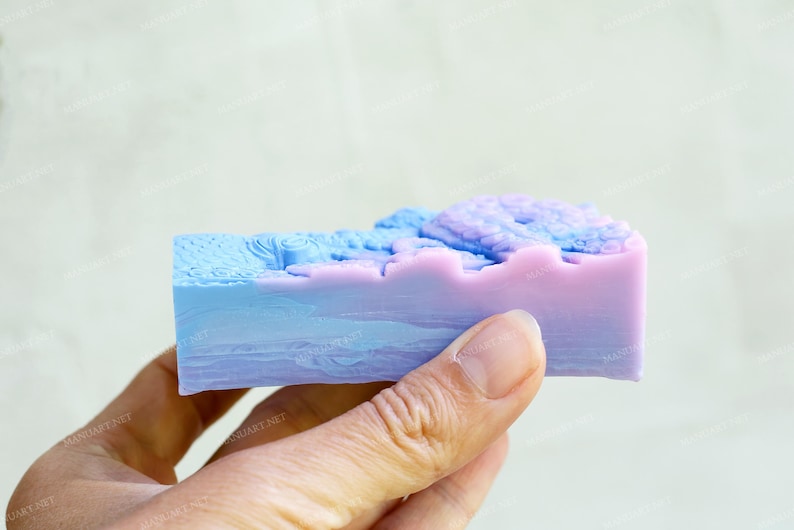 May include: A bar of soap with a blue and purple swirl design. The soap is in the shape of a rectangle and has a textured surface.