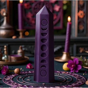 Può includere: Una candela a forma di obelisco viola scuro con intagli a fasi lunari, circondata da candele viola accese in portacandele dorati, fiori viola ed elementi decorativi. La scena è ambientata su una superficie verde acqua scuro.