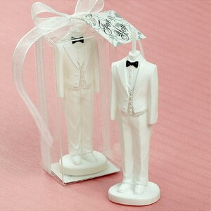 May include: White tuxedo-shaped candle in a clear plastic box with a white ribbon and a tag that says "For You".
