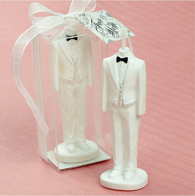 May include: White tuxedo-shaped candle in a clear plastic box with a white ribbon and a tag that says "For You".