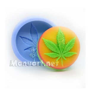 May include: A silicone mold for making soap or resin crafts. The mold is shaped like a round cannabis leaf with a green and yellow gradient. The mold is shown with a finished soap bar in the shape of the leaf.