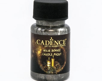 May include: A bottle of Cadence Art & Hobby Paints candle paint. The bottle has a black cap and a label with text and a candle graphic. The paint is a metallic silver color.