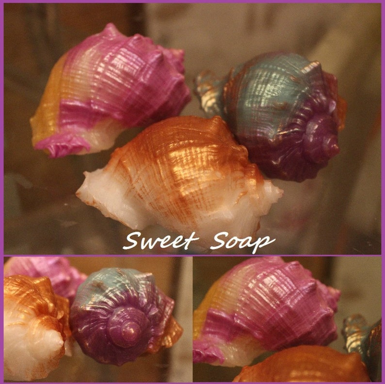 May include: Four handmade soap bars shaped like seashells. The soaps are in shades of pink, purple, gold, and green. The soaps are arranged on a glass surface. The text "Sweet Soap" is written on the image.
