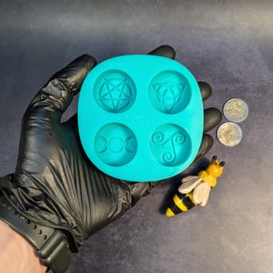 Create detailed small ritual pieces with this witchcraft symbols mold for tealight candles, designed with 4 cavities: Triskelion, Triple Moon, Pentagram, and Triquetra. This food grade silicone candle mold is sized to match US and EU tealight standards.
Candle mold, wiccan mold, pagan mold, Celtic molds, metaphysical mold, pagan silicone mold, wax melts mold, witchcraft mold, symbols mold, mold for tealight, magic mold, spiritual mold, wicca mould