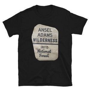 Puede incluir: Camiseta negra con un gráfico de un letrero de madera que dice "Ansel Adams Wilderness Inyo National Forest".