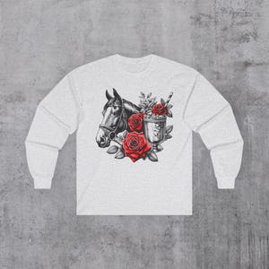 Może przedstawiać: Biały t-shirt z długim rękawem z czarno-białą ilustracją głowy konia, czerwonych róż i szklanki z napojem i słomką.