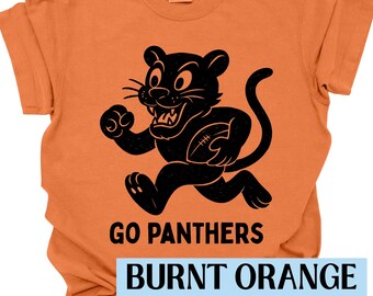 May include: Burnt orange t-shirt with a black panther graphic holding a football. The text "GO PANTHERS" is above the text "BURNT ORANGE" in a light blue rectangle. The shirt is a Comfort Colors brand.