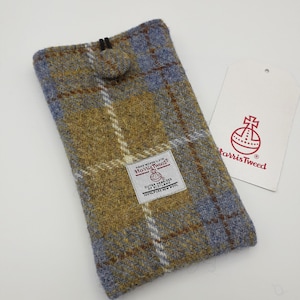 Könnte beinhalten: Eine Handyhülle aus Harris Tweed-Stoff in blauem und gelbem Karomuster. Die Hülle hat einen Knopfverschluss und ein Etikett mit der Aufschrift "Hand Woven Cloth Harris Tweed Outer Hebrides of Scotland 100% Pure New Wool".