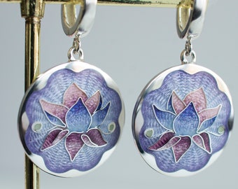 May include: A pair of silver earrings with a purple and blue enamel lotus flower design.