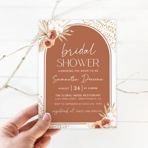 May include: A rectangular invitation card with a terracotta arch design, featuring the words "bridal shower" and details for Samantha Donovan's event on August 24th at 3:00 PM. Floral accents and gold confetti add to the design.