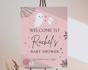 Könnte beinhalten: Rosa Willkommens-Schild mit schwarzem Text, der "Willkommen zu Rachels Baby Shower am 21. Oktober 2023" lautet. Das Schild zeigt zwei weiße Geister mit schwarzen Augen und rosa Herzen.