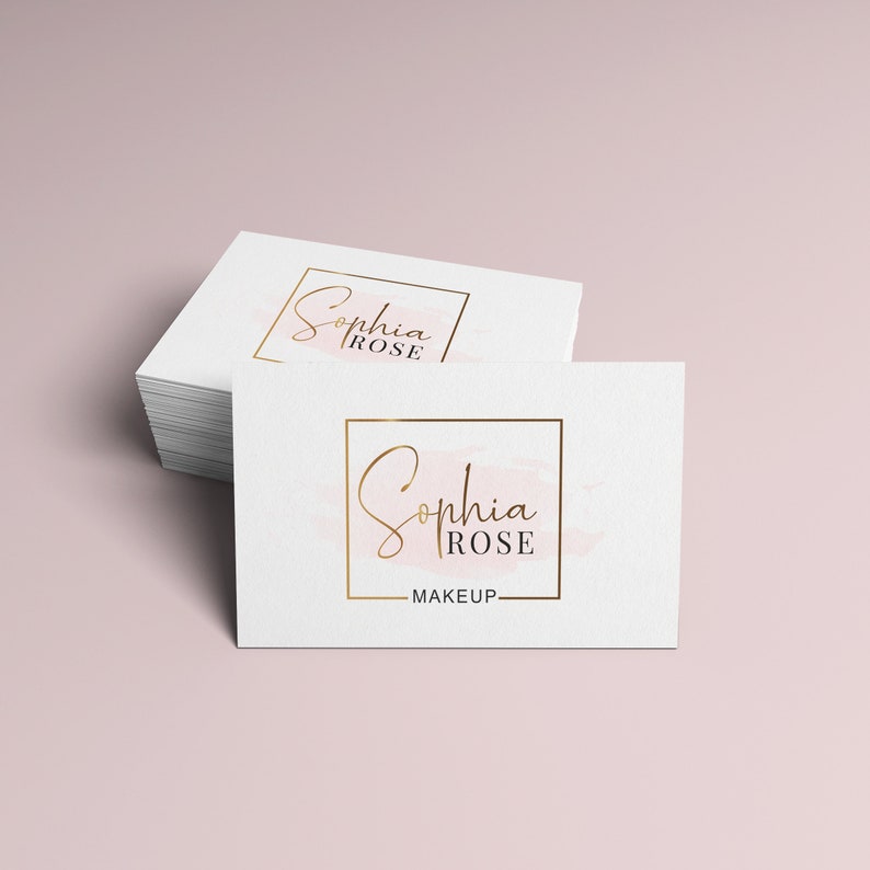 May include: Two white business cards with a gold square frame around the text "Sophia Rose Makeup". The text is in a cursive font and the background is a light pink watercolor wash.