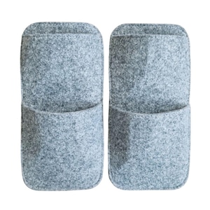 May include: Two gray felt wall organizers with a pocket design. The organizers are rectangular with rounded tops and a single pocket on the front. The felt material has a speckled texture, and the background is white.