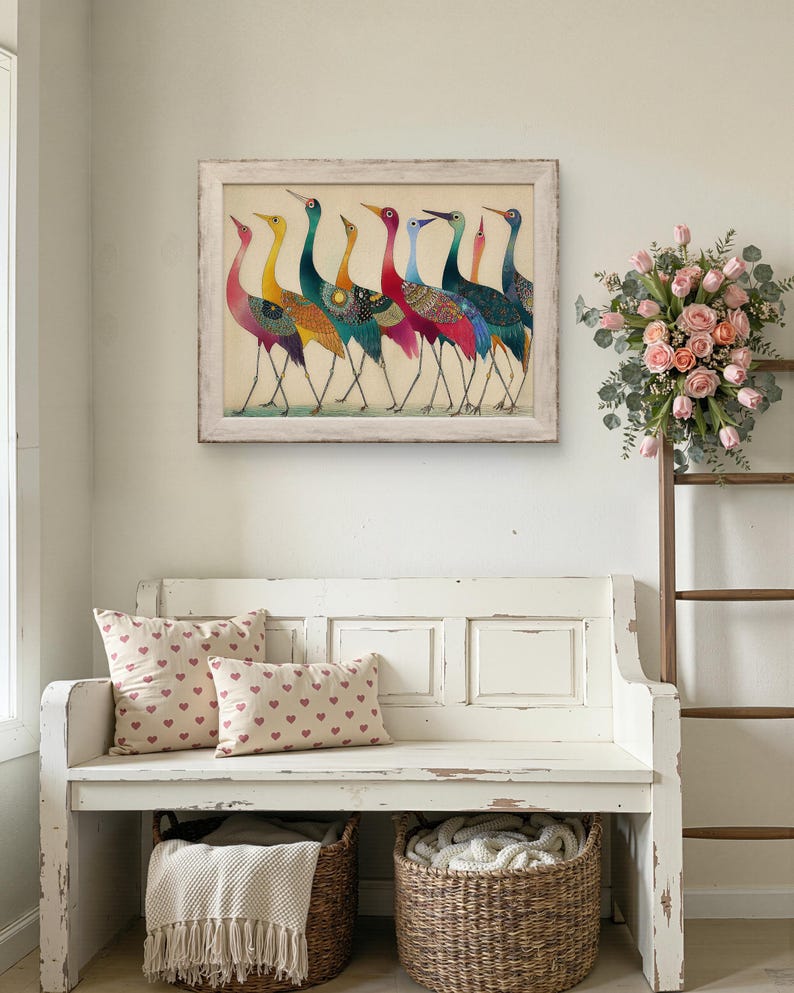 May include: A framed artwork featuring seven colorful birds with long necks and legs. The birds have a variety of colors, including yellow, teal, red, and blue. Below the artwork is a white bench with two heart-patterned pillows and two wicker baskets.