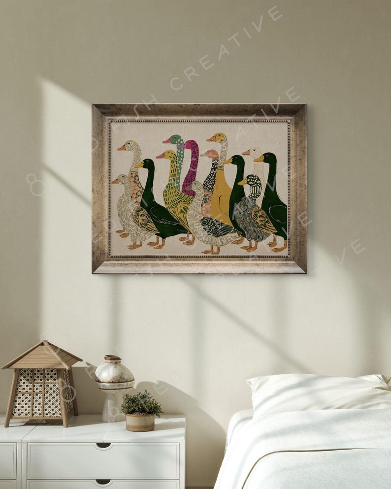 K&ouml;nnte beinhalten: Ein gerahmter Kunstdruck mit einer Gruppe von Enten in verschiedenen Farben und Mustern, darunter Gr&uuml;n, Gelb, Rosa und Braun. Die Enten sind im Seitenprofil dargestellt und stehen in einer Reihe vor einem hellen, strukturierten Hintergrund.