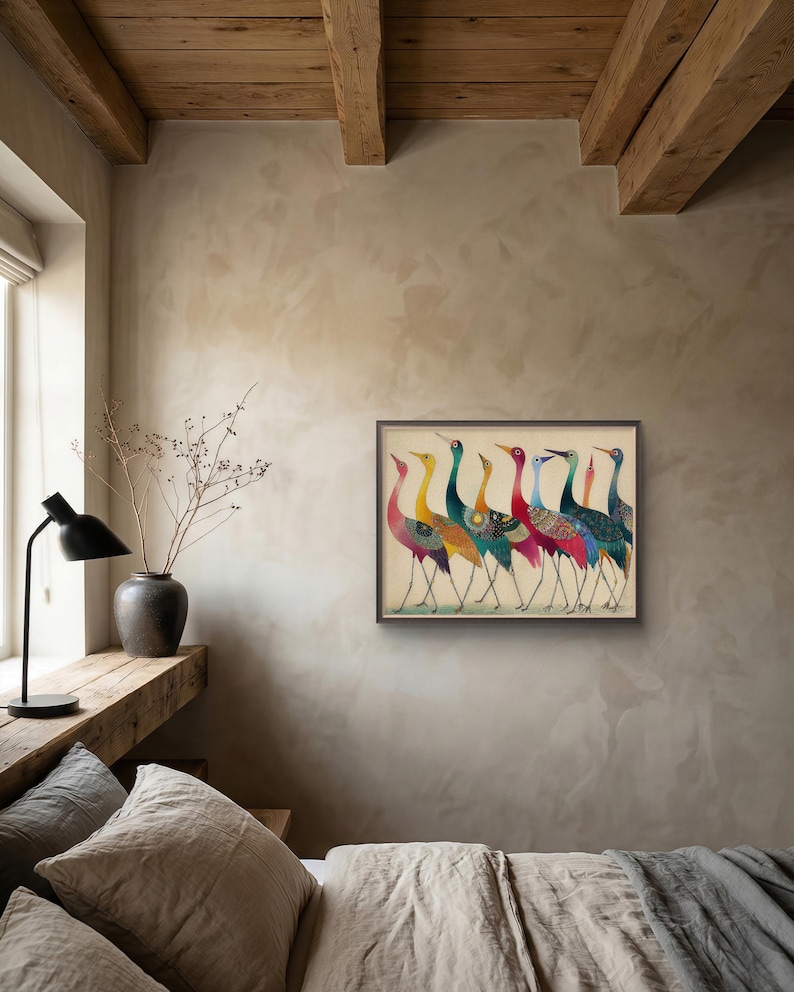 May include: A framed artwork featuring a line of stylized cranes with colorful plumage. The birds have long legs and necks, with a variety of patterns and colors including red, yellow, blue, and green. The artwork is displayed in a room with neutral-toned walls.
