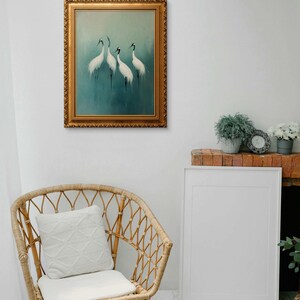 May include: A framed painting of four white cranes standing on a blue and green background. The frame is gold and ornate.