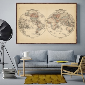 May include: A vintage world map print in a brown frame, showing the Western and Eastern Hemispheres. The map is printed on aged paper with a cream background and features detailed lines and markings.