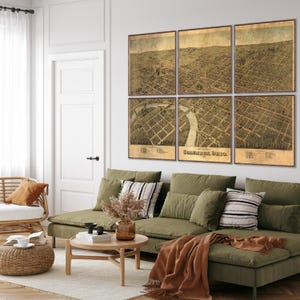 May include: A living room with a green sectional sofa, a coffee table, and a wicker chair. The wall behind the sofa is decorated with a vintage map of Columbus, Ohio, divided into six panels.