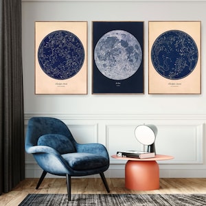 May include: Three framed prints with a celestial theme. The prints feature a moon with constellations, a moon with a detailed surface, and a moon with a constellation map. The prints are in a cream frame with a white mat.