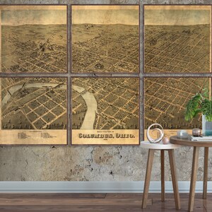 May include: An antique map of Columbus, Ohio, divided into six sections, showing the city's layout in 1875. The map is printed on aged paper with a brown and beige color scheme. The map is framed and displayed on a wall.