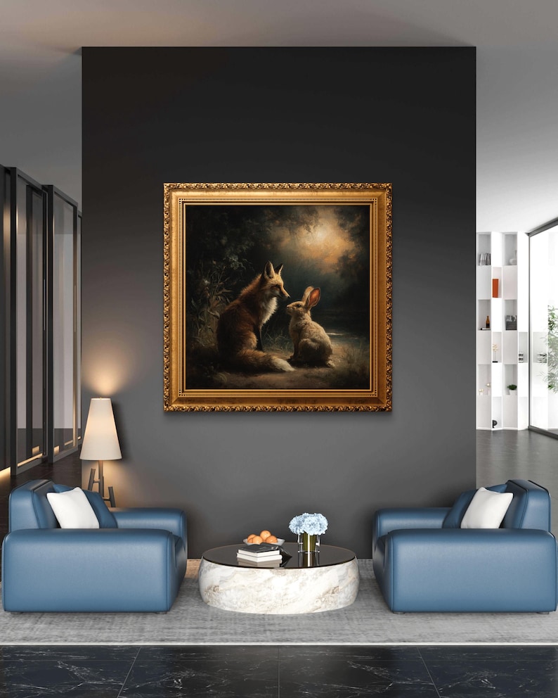 May include: A framed painting depicts a fox and a rabbit in a forest setting. The artwork features warm tones, with the fox in shades of brown and the rabbit in white and gray. The painting is in a gold ornate frame, hanging on a dark gray wall.