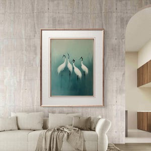 May include: A framed print of four white cranes with black heads and beaks standing on a blue-green background. The cranes are arranged in a semi-circle formation. The frame is a simple, gold-colored frame.