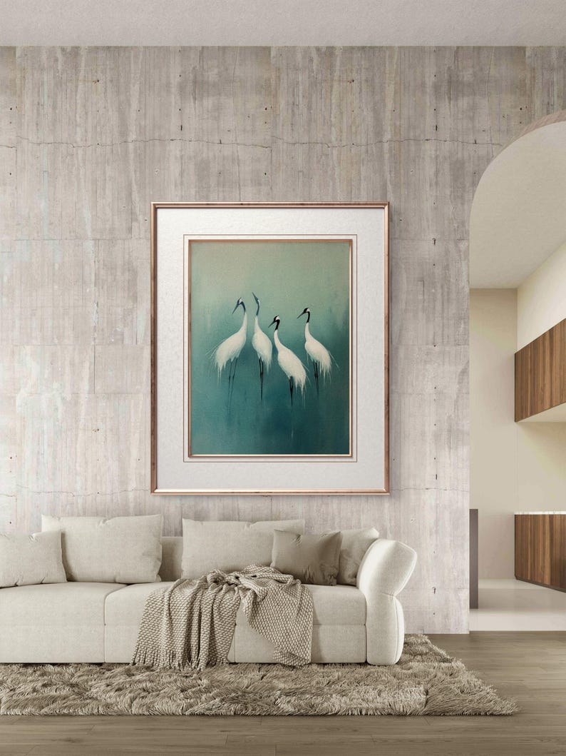 May include: A framed print of four white cranes with black heads and beaks standing on a blue-green background. The cranes are arranged in a semi-circle formation. The frame is a simple, gold-colored frame.