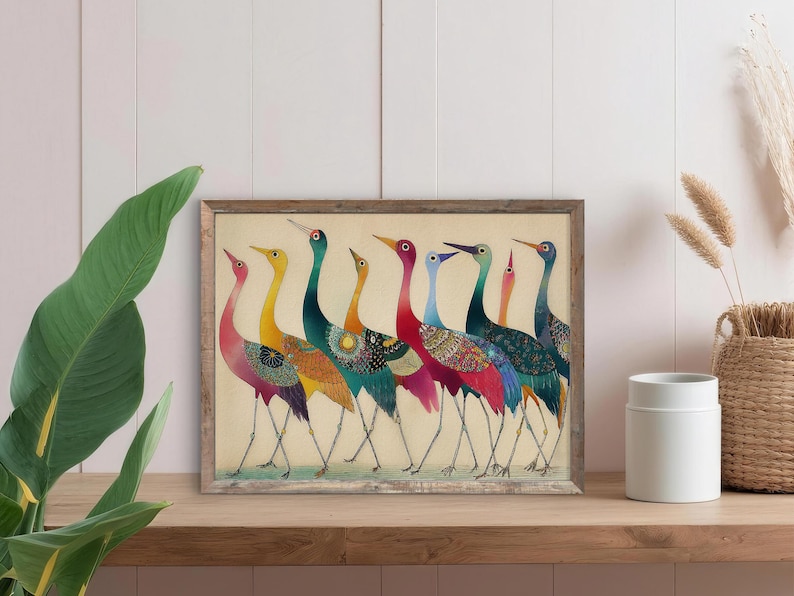 May include: A framed art print featuring a line of colorful birds with long necks and legs. The birds have a variety of colors, including red, yellow, blue, and green, with patterned details on their bodies. The artwork is displayed on a wooden shelf.