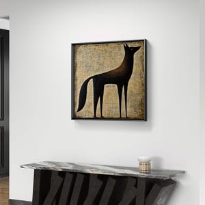 K&ouml;nnte beinhalten: Ein Schwarzwei&szlig;bild eines stilisierten Wolfes, der auf einem strukturierten beigefarbenen Hintergrund steht. Das Bild ist in einem schwarzen Rahmen gerahmt und h&auml;ngt an einer wei&szlig;en Wand &uuml;ber einem schwarzen Marmor-Konsolentisch.
