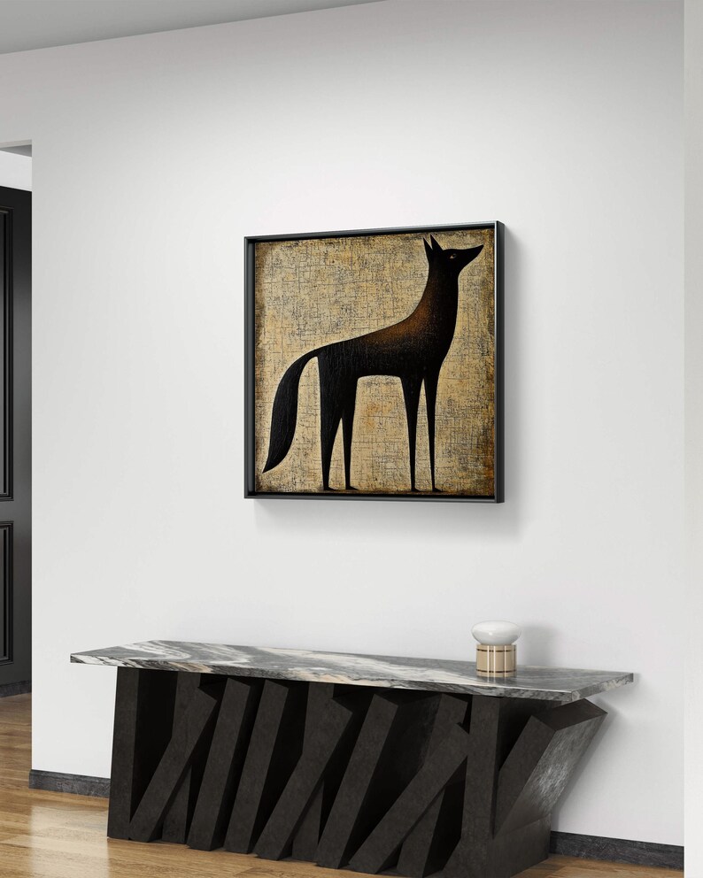 K&ouml;nnte beinhalten: Ein Schwarzwei&szlig;bild eines stilisierten Wolfes, der auf einem strukturierten beigefarbenen Hintergrund steht. Das Bild ist in einem schwarzen Rahmen gerahmt und h&auml;ngt an einer wei&szlig;en Wand &uuml;ber einem schwarzen Marmor-Konsolentisch.
