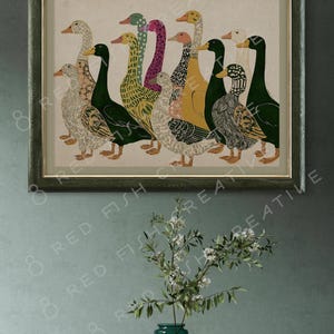 K&ouml;nnte beinhalten: Ein gerahmter Kunstdruck mit einer Gruppe von Enten in verschiedenen Farben und Mustern, darunter Gr&uuml;n, Gelb, Rosa und Schwarz. Die Enten sind in einer Reihe vor einem hellbeigen Hintergrund angeordnet und in einem dunkelgr&uuml;nen Holzrahmen.