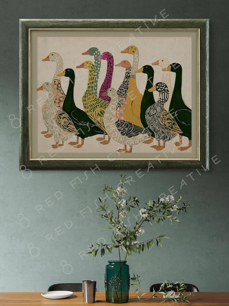 K&ouml;nnte beinhalten: Ein gerahmter Kunstdruck mit einer Gruppe von Enten in verschiedenen Farben und Mustern, darunter Gr&uuml;n, Gelb, Rosa und Schwarz. Die Enten sind in einer Reihe vor einem hellbeigen Hintergrund angeordnet und in einem dunkelgr&uuml;nen Holzrahmen.