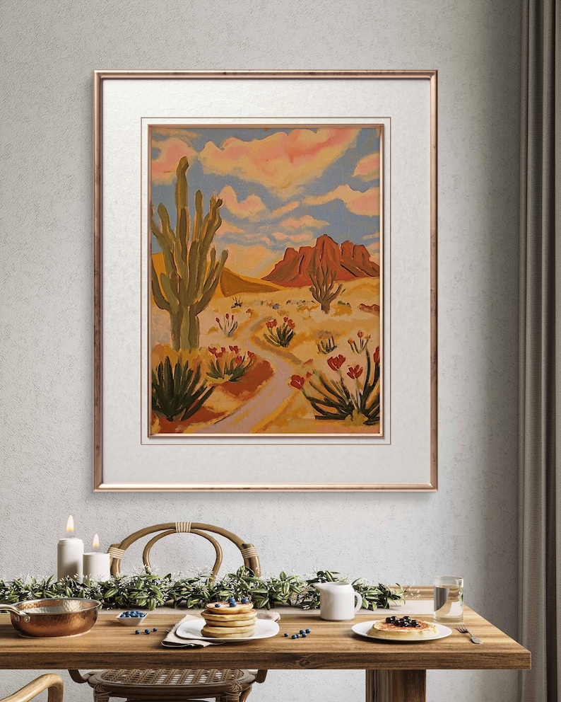 May include: A painting of a desert landscape with a tall cactus in the foreground, red mountains in the background, and a winding path leading through the scene.