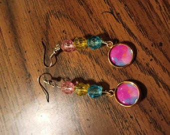 Pendientes colgantes de cuentas inspirados en la bandera pansexual con colgantes redondos rosados y púrpuras arremolinados