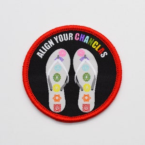 May include: Red embroidered patch with black background and white text that says "Align Your Chanclas". The patch features two white flip-flops with colorful designs.